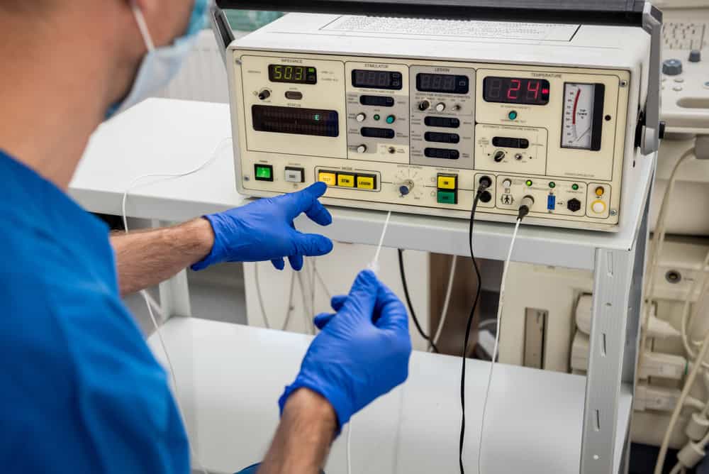 A pain management specialist in NYC performing radiofrequency ablation on a patient’s spine, using image-guided technology to treat chronic back or neck pain.
