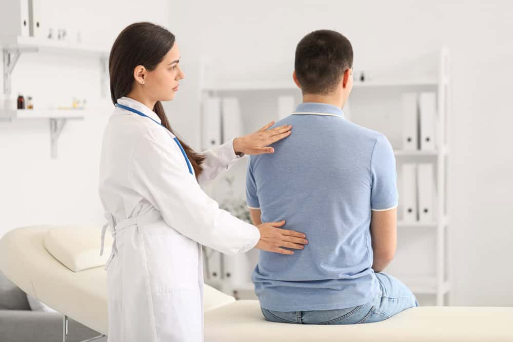 A physiotherapist in NYC working with a patient to assess and treat acute vs chronic back pain, highlighting personalized care plans for both short-term injuries and long-term spinal conditions.